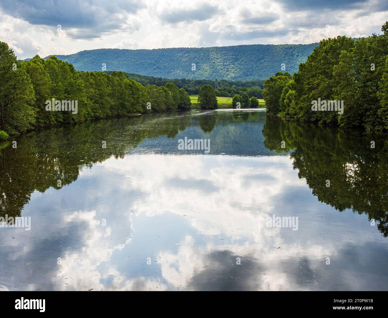La South Fork del fiume Shenandoah in Virginia, USA, vanta acque tranquille che riflettono alberi, cielo, nuvole e montagne lontane. Foto Stock