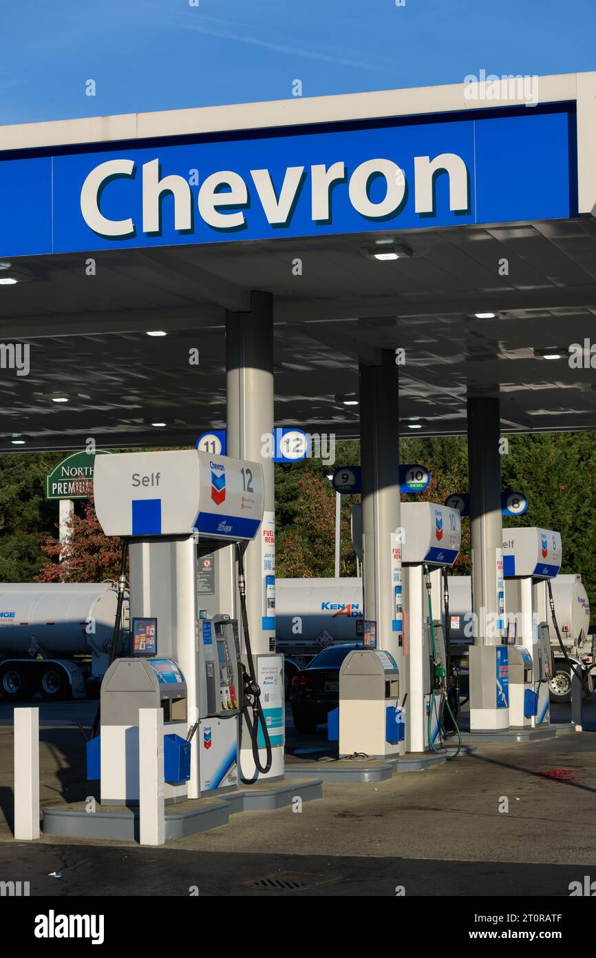 North Bend, WA, USA - 8 ottobre 2023; cartello di apertura e pompe presso la stazione di servizio Chevron di giorno Foto Stock