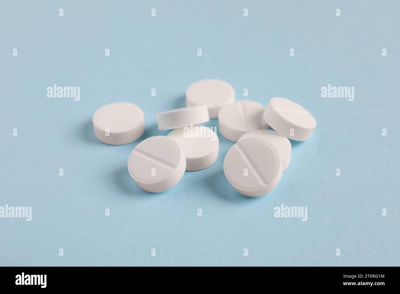 Pila di pillole bianche su sfondo azzurro, primo piano Foto Stock