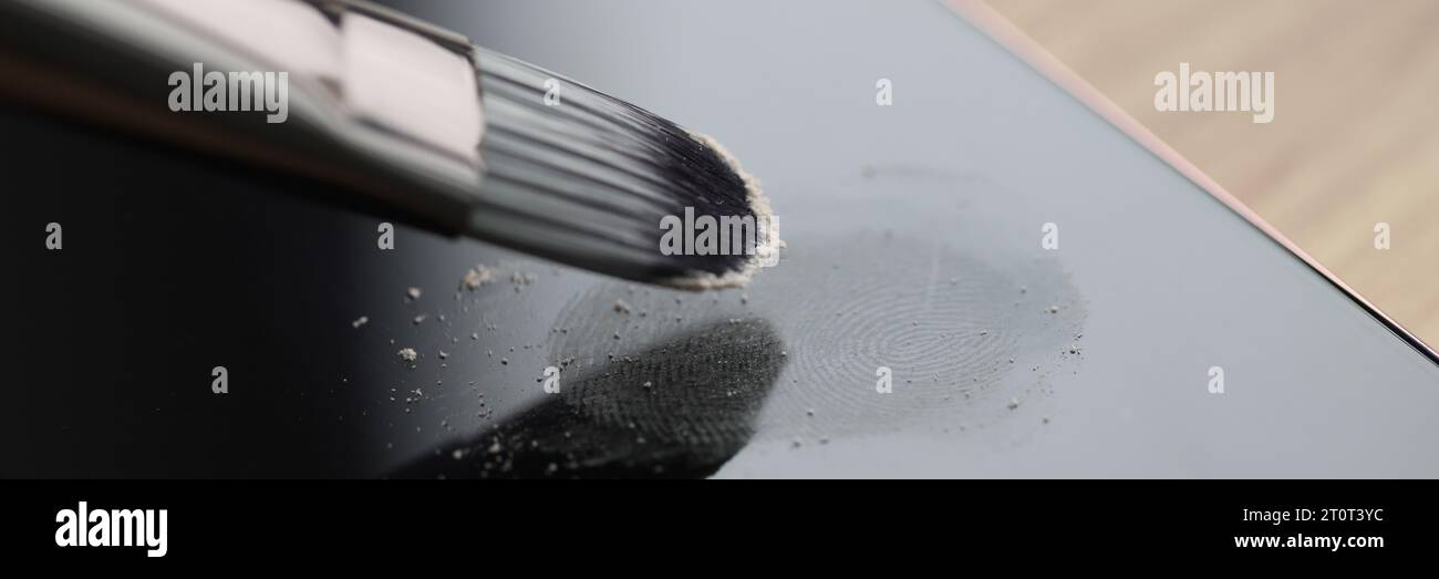 Il pennello piccolo elabora le impronte digitali lasciate sullo schermo del telefono Foto Stock
