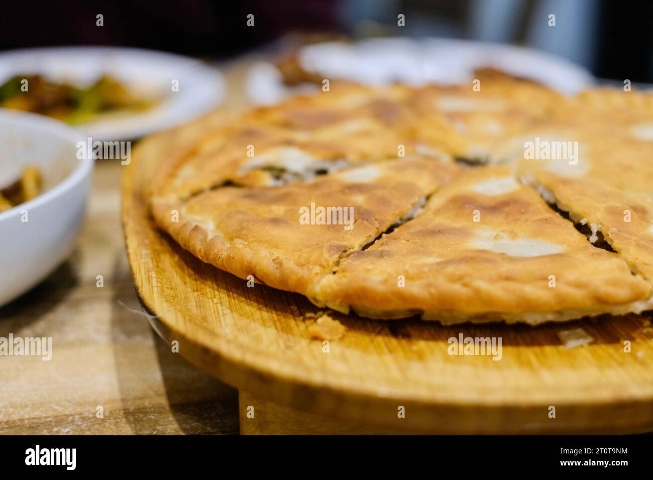 Goshnan, o gosh-naan, una tradizionale torta uigura ripiena di carne tritata speziata (manzo e agnello) e cipolle all'Apandim Uyghur Restaurant di Sydney Foto Stock