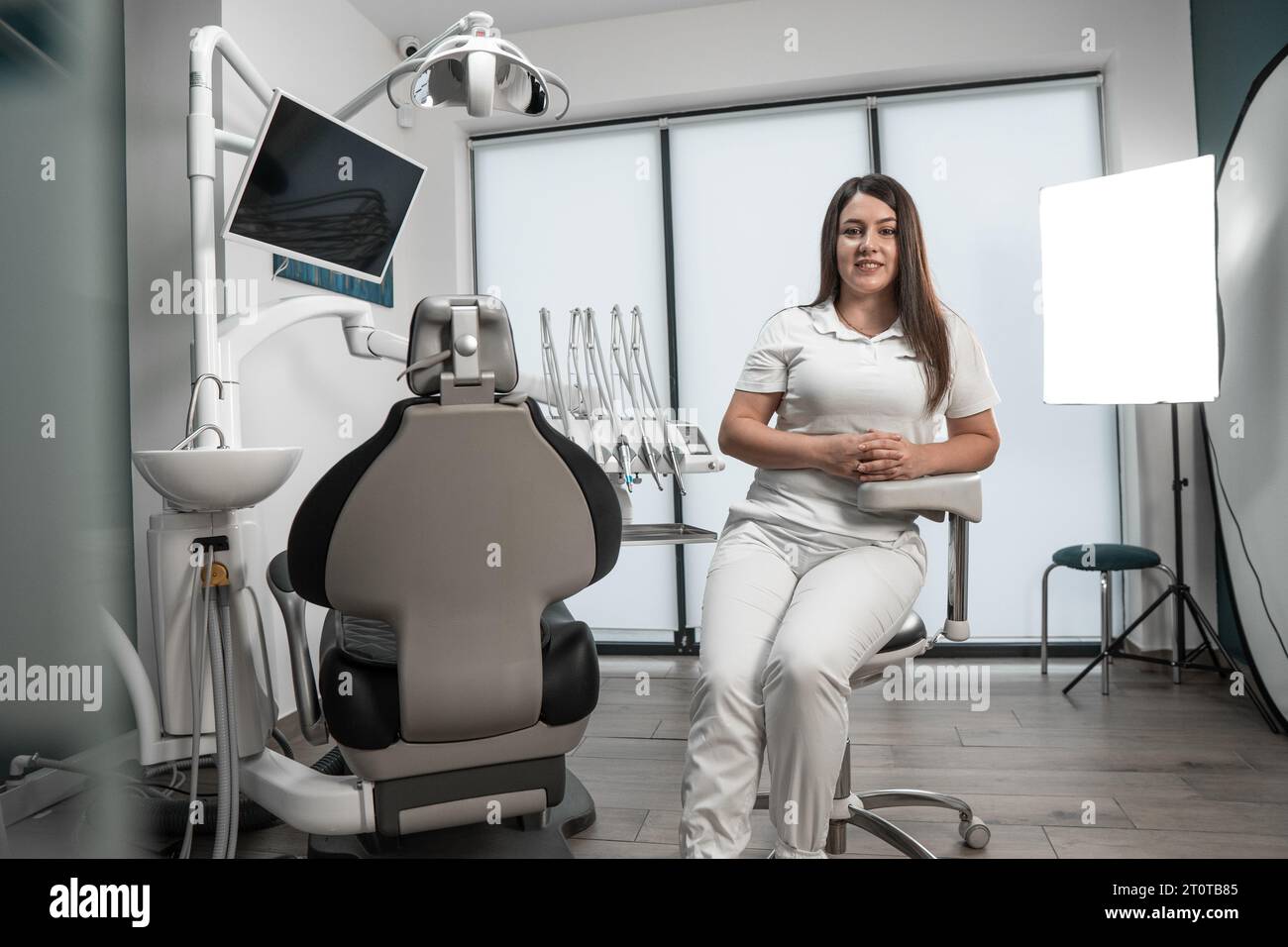 Il medico posa e guarda la telecamera. Il trattamento della carie viene effettuato da un dentista professionista che utilizza tecnologie moderne. Il centro odontoiatrico Foto Stock