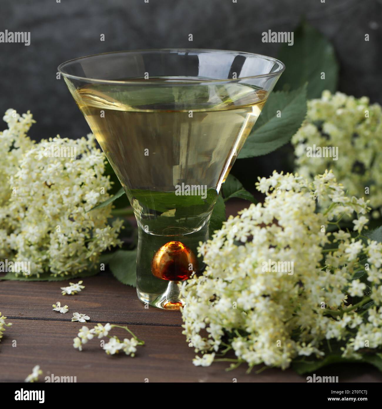 vetro originale con liquore di fiori di sambuco con decorazione di fiori di sambuco su sfondo di legno Foto Stock