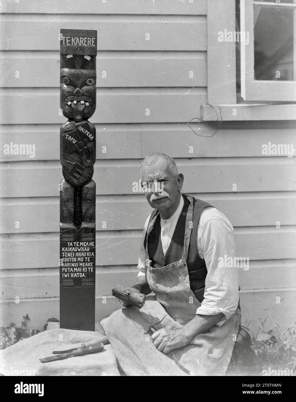 Albert Percy Godber (fotografo neozelandese) - lavorando su una scultura Maori - c1932 Foto Stock
