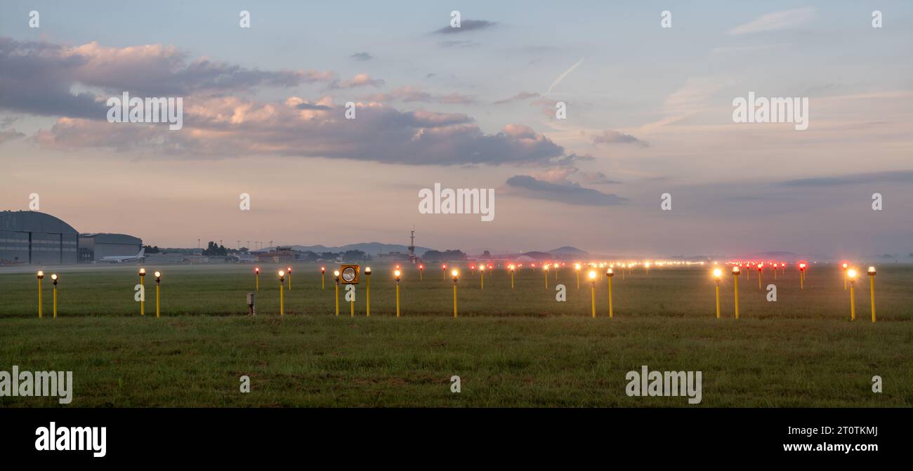 Illuminazione della pista durante una mattinata molto nebbiosa Foto Stock