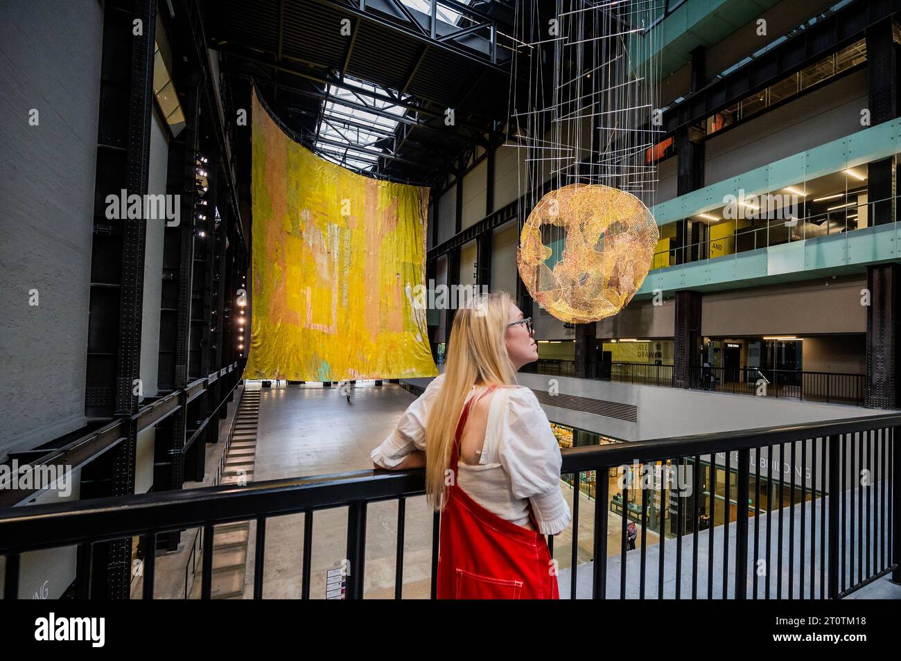 Londra, Regno Unito. 9 ottobre 2023. Commissione Hyundai: El Anatsui: Dietro la Luna Rossa nella Tate Modern's turbine Hall. Le immagini DEVONO essere utilizzate SOLO quando si fa riferimento a questa installazione. El Anatsui, nato in Ghana e con sede in Nigeria, è famoso per le sue sculture metalliche a cascata costruite con migliaia di bottiglie riciclate articolate con filo di rame. Riadattando i materiali trovati in splendide opere d'arte astratta, il lavoro di Anatsui esplora temi che includono l'ambiente, il consumo e il commercio. Crediti: Guy Bell/Alamy Live News Foto Stock