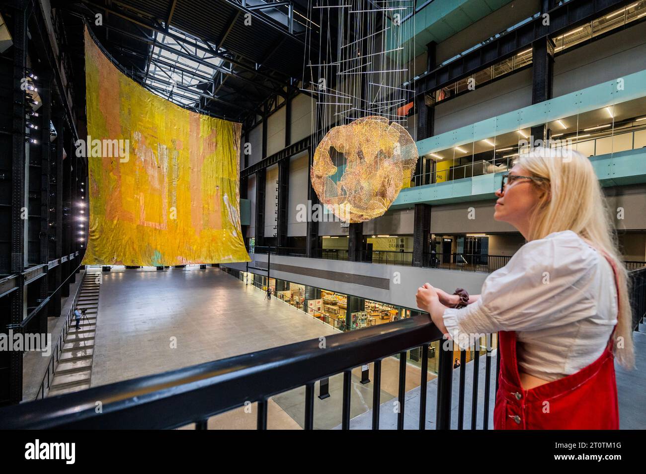 Londra, Regno Unito. 9 ottobre 2023. Commissione Hyundai: El Anatsui: Dietro la Luna Rossa nella Tate Modern's turbine Hall. Le immagini DEVONO essere utilizzate SOLO quando si fa riferimento a questa installazione. El Anatsui, nato in Ghana e con sede in Nigeria, è famoso per le sue sculture metalliche a cascata costruite con migliaia di bottiglie riciclate articolate con filo di rame. Riadattando i materiali trovati in splendide opere d'arte astratta, il lavoro di Anatsui esplora temi che includono l'ambiente, il consumo e il commercio. Crediti: Guy Bell/Alamy Live News Foto Stock