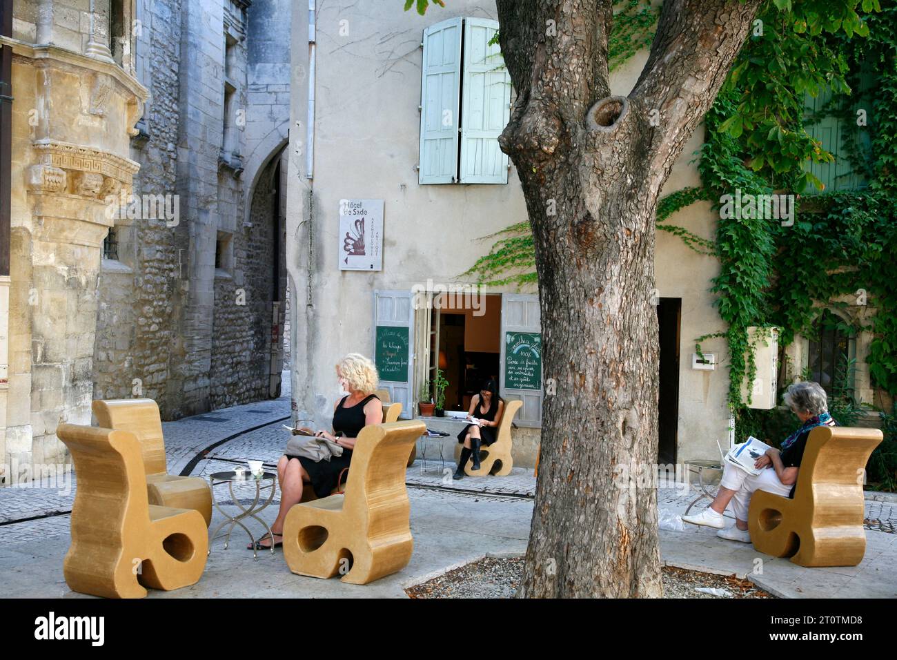 Persone sedute in un caffè in Place Favier nel quartiere vecchio, St Remy de Provence, Buches du Rhone, Provence, Francia. Foto Stock