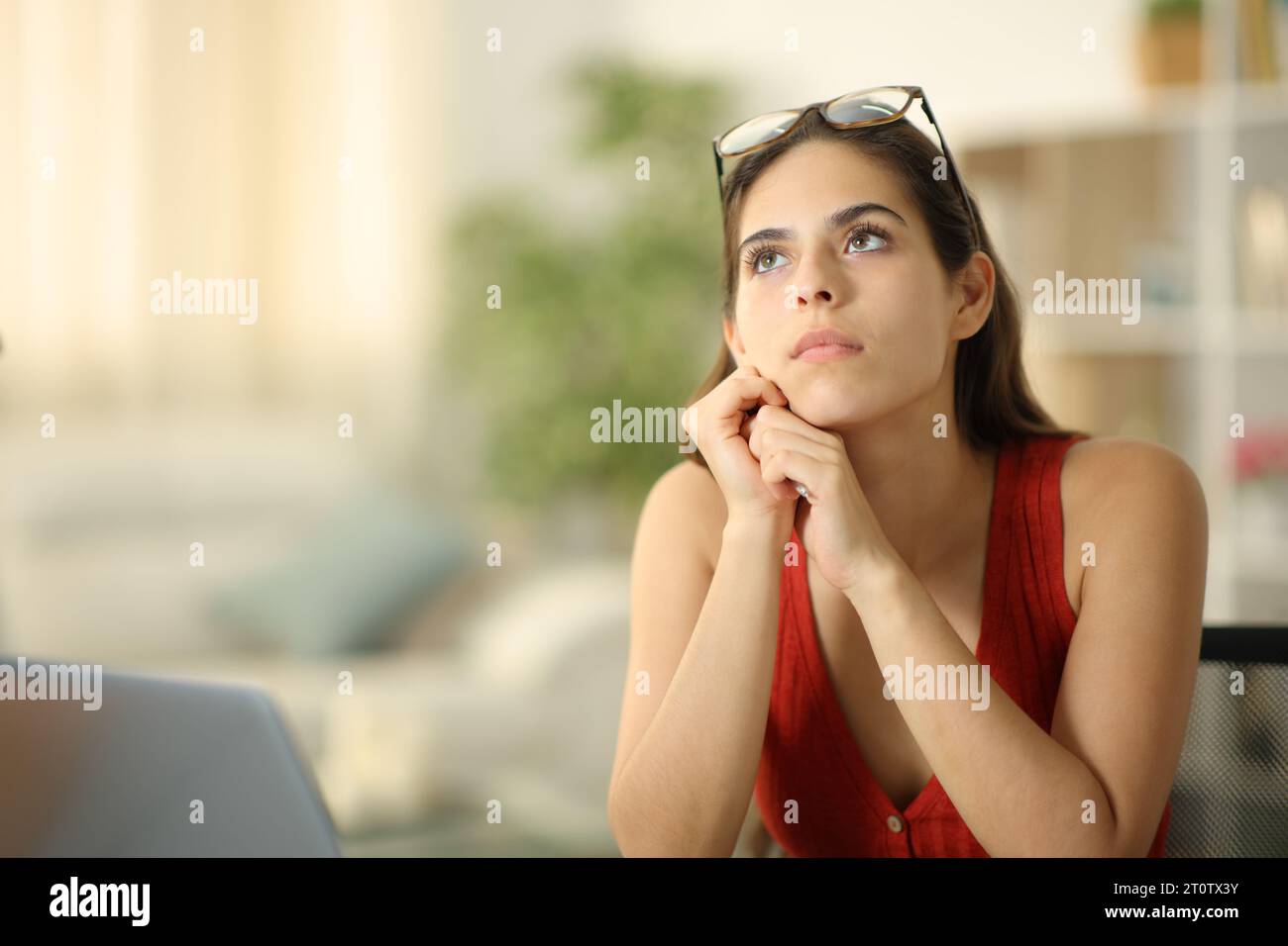 Donna distratta che pensa di guardare sopra a casa Foto Stock