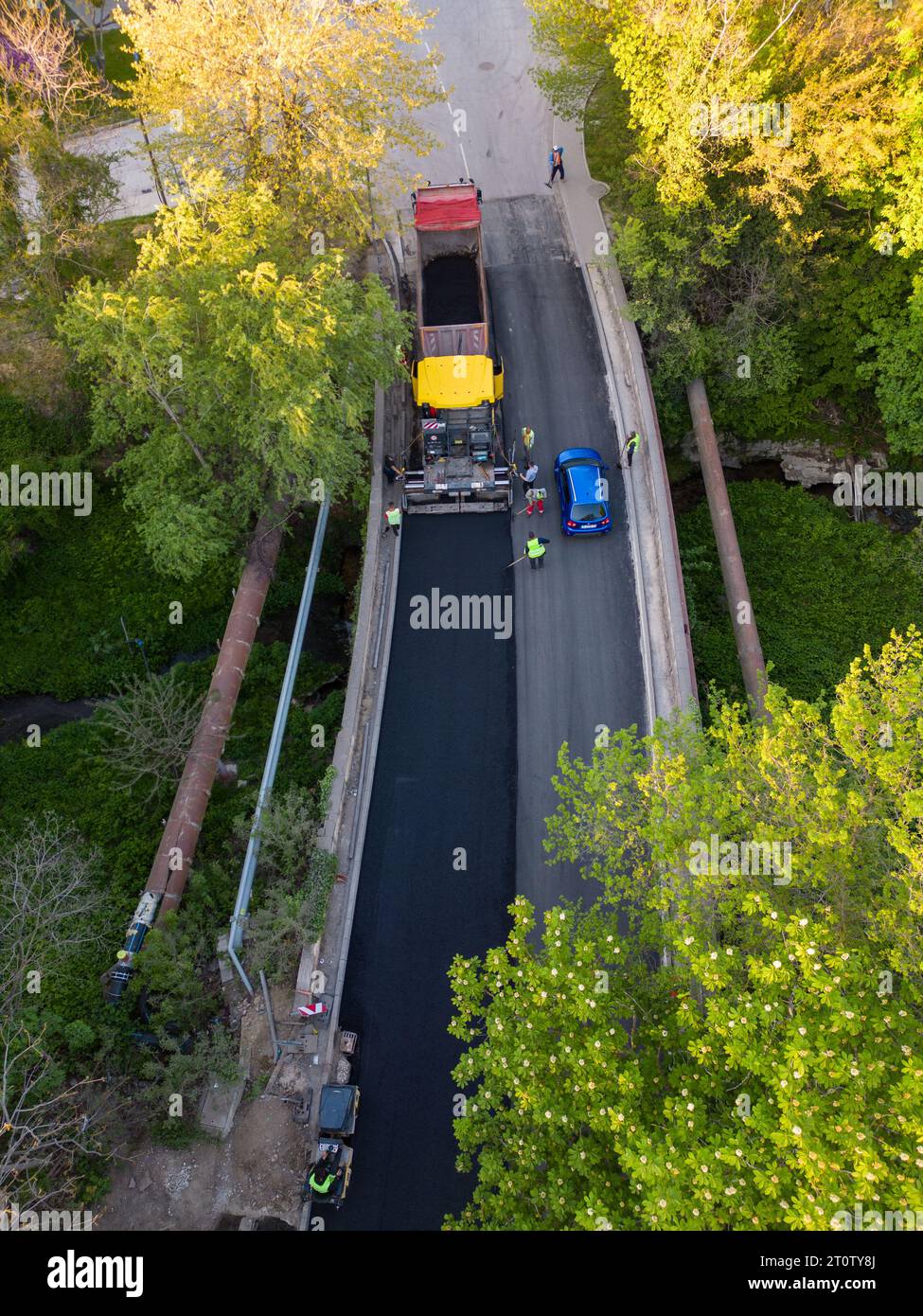 Vista aerea della costruzione di una nuova strada, con asfaltatrici, rulli, macchinari e lavoratori che si uniscono per costruire un collegamento di trasporto vitale. W Foto Stock