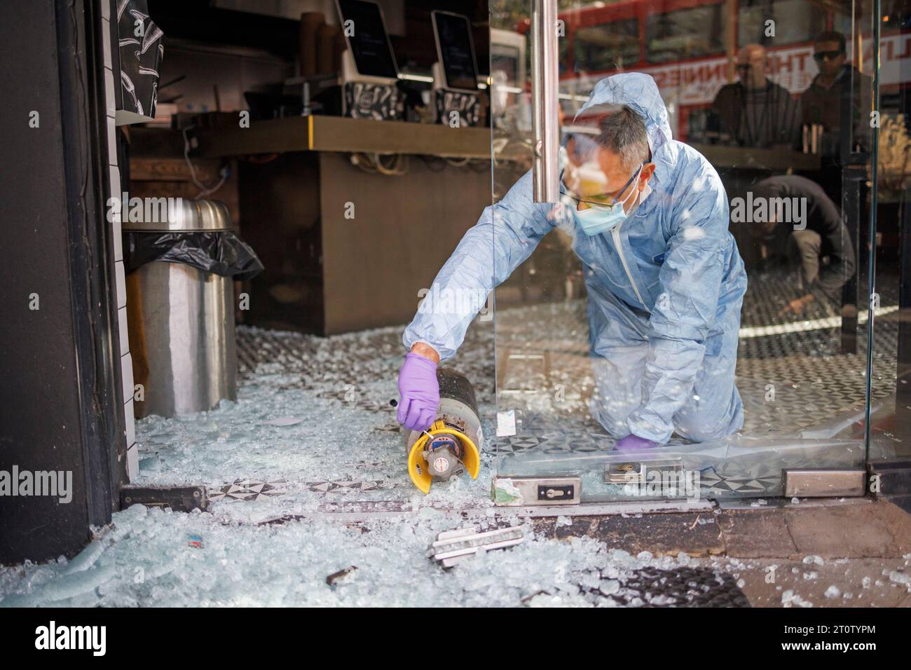 Londra, Regno Unito. 9 ottobre 2023. Un agente forense della polizia tampona una tanica sulla scena del Pita, un ristorante Kosher a Golders Green, a nord di Londra, che ha fatto rompere la porta di vetro e derubare i contenuti. Su un ponte ferroviario vicino è stato dipinto lo spray "Free Palestine". La polizia di Londra sta intensificando le sue pattuglie a seguito di un'escalation nel conflitto tra Isreal e Hamas. Crediti fotografici: Ben Cawthra/Sipa USA credito: SIPA USA/Alamy Live News Foto Stock