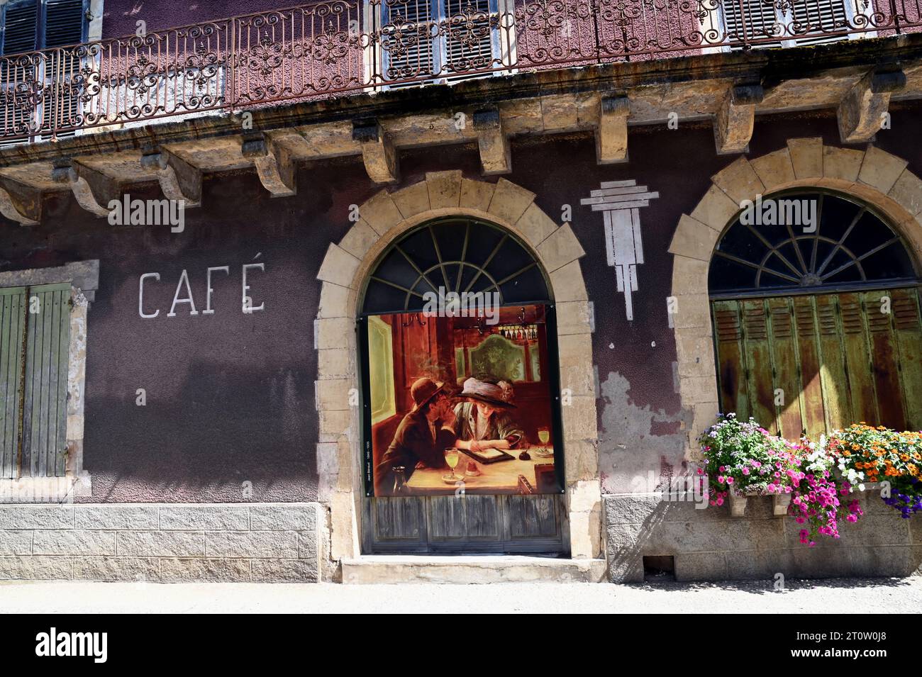 Un edificio abbandonato in una strada nella città di Villefranche du Perigord, Dordogna. Una scena è stata dipinta su una porta per sembrare un caffè. Foto Stock