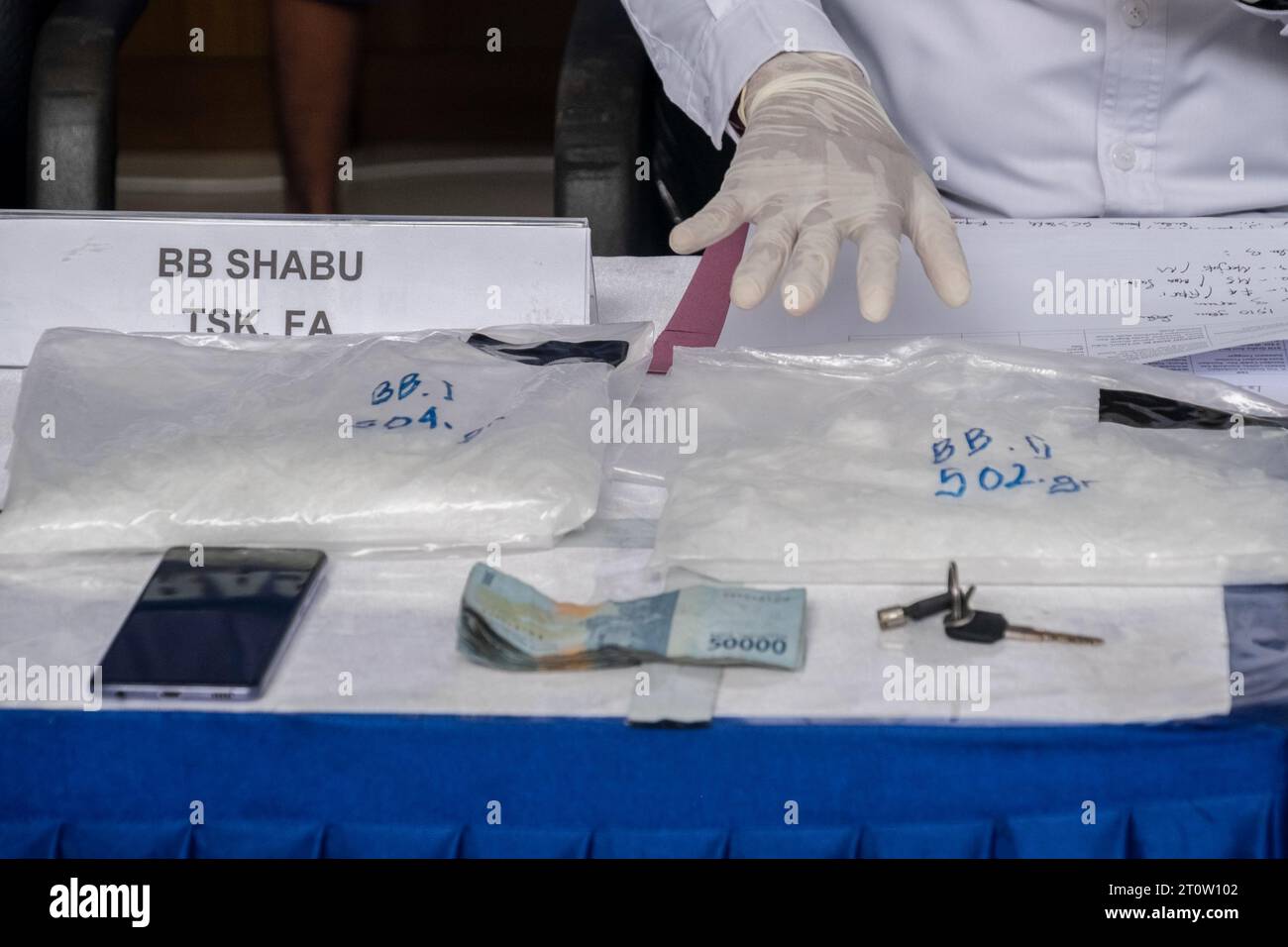 Kendari, Indonesia. 9 ottobre 2023. Gli agenti di BNN Sultra mostrano, insieme a contanti e altri oggetti confiscati, prove di narcotici di tipo metanfetamina avvolte in confezioni di plastica presso l'ufficio BNN Sultra. L'Agenzia nazionale per gli stupefacenti (BNN) della provincia di Sulawesi sud-orientale è riuscita ad arrestare tre sospettati nel caso di contrabbando di metanfetamina del peso di 1 chilo, 500 grammi e 10 grammi in 2 diverse località. (Foto di Andry Denisah/SOPA Images/Sipa USA) credito: SIPA USA/Alamy Live News Foto Stock