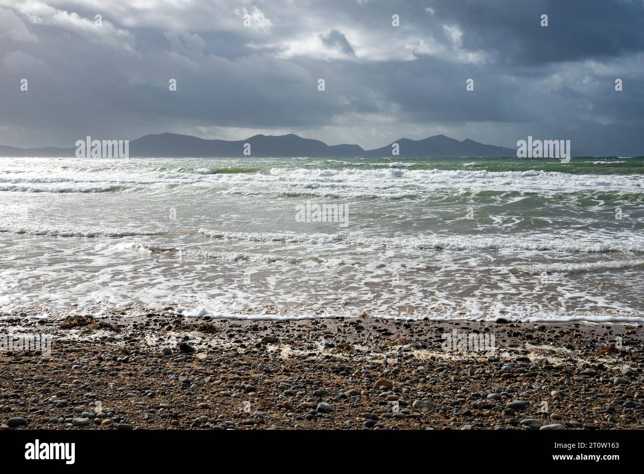 Newborough Beach, Anglesey, Galles del Nord. Vista sulle onde delle montagne sulla terraferma gallese. Foto Stock