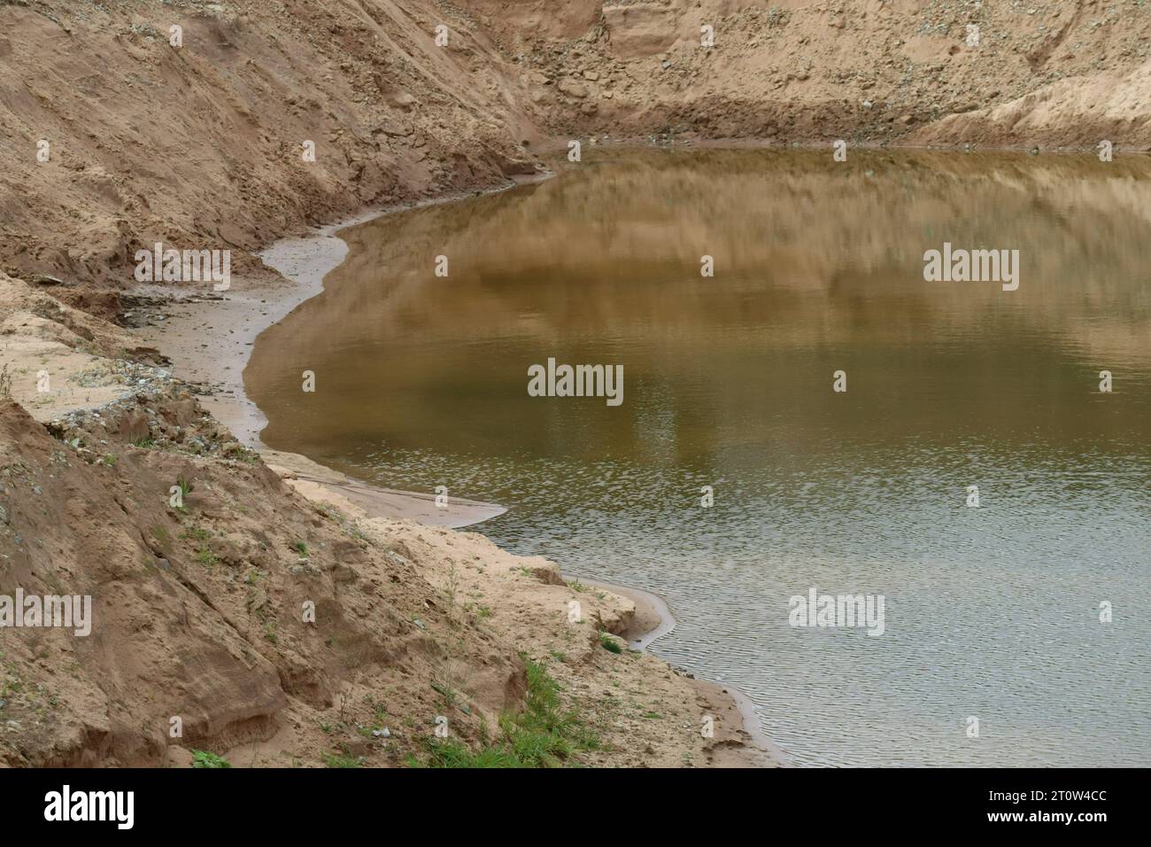 L'acqua piovana si riflette in una fossa di sabbia Foto Stock