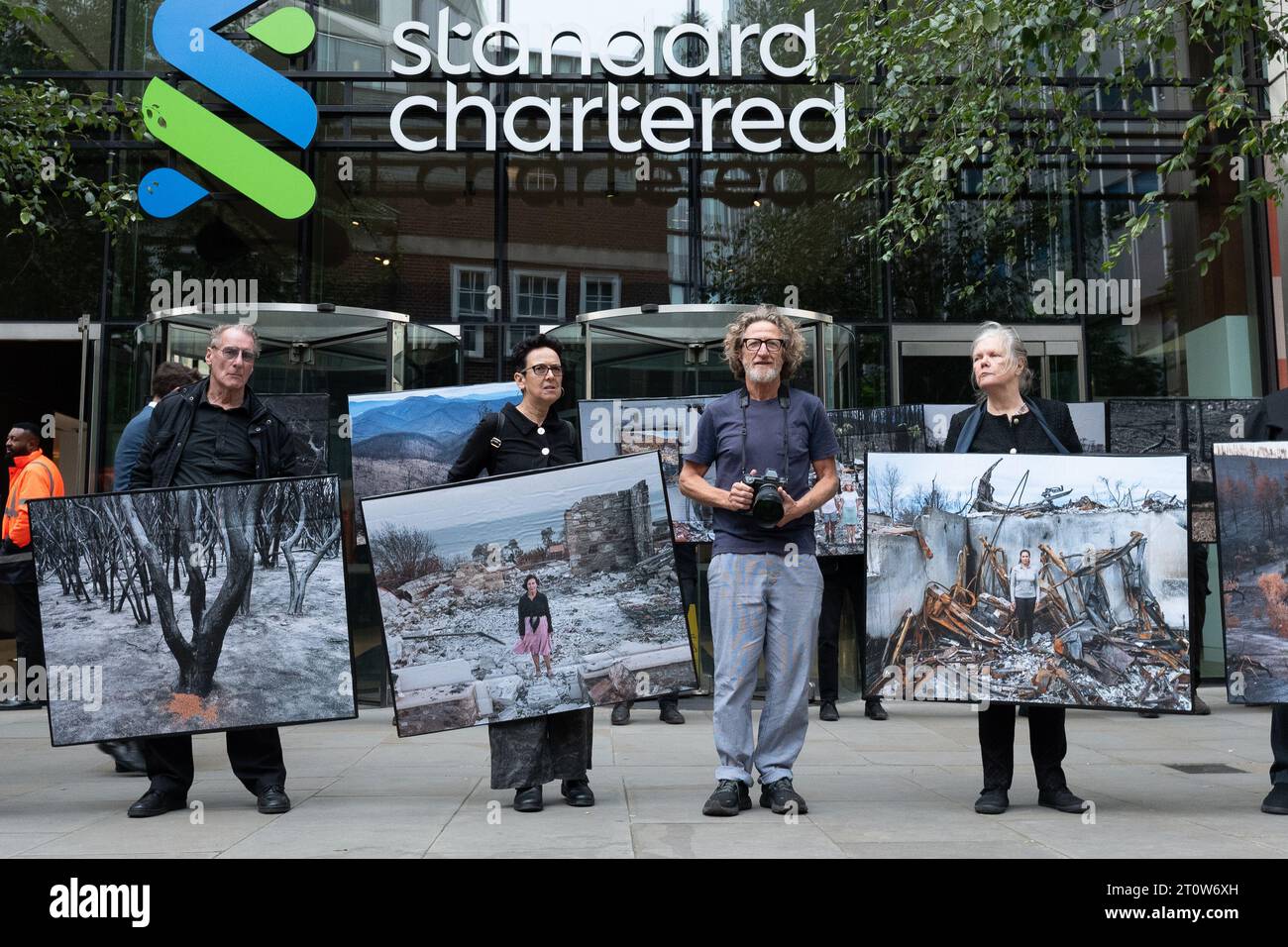 Londra, Regno Unito. 9 ottobre 2023. Mostra di protesta pop-up di immagini delle conseguenze di incendi boschivi del fotografo Gideon Mendel esposte fuori dalla Standard Chartered Bank, uno dei principali finanziatori dei combustibili fossili che, secondo gli scienziati, aumentano la probabilità, la durata e la gravità di tali incendi. L'evento, organizzato da Money Rebellion, è stato programmato in coincidenza con il concorso "fotografo meteorologico dell'anno" della Royal Meteorological Society, sponsorizzato da Standard Chartered. Crediti: Ron Fassbender/Alamy Live News Foto Stock