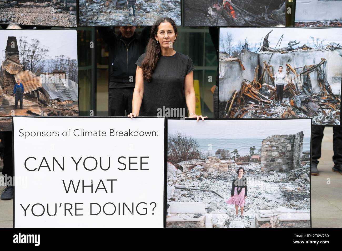 Londra, Regno Unito. 9 ottobre 2023. Mostra di protesta pop-up di immagini delle conseguenze di incendi boschivi del fotografo Gideon Mendel esposte fuori dalla Standard Chartered Bank, uno dei principali finanziatori dei combustibili fossili che, secondo gli scienziati, aumentano la probabilità, la durata e la gravità di tali incendi. L'evento, organizzato da Money Rebellion, è stato programmato in coincidenza con il concorso "fotografo meteorologico dell'anno" della Royal Meteorological Society, sponsorizzato da Standard Chartered. Crediti: Ron Fassbender/Alamy Live News Foto Stock