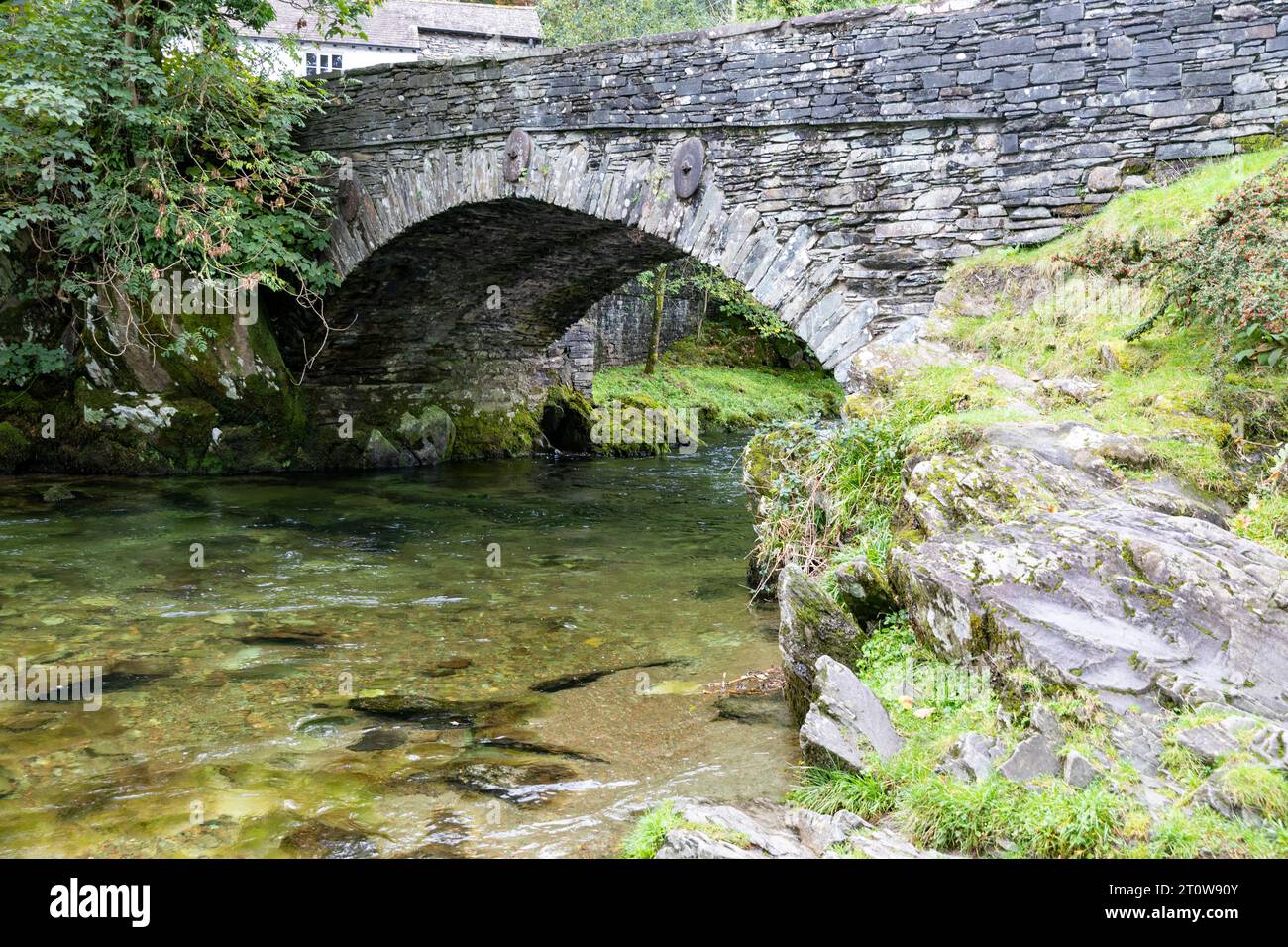 Elterwater Village e ponte nel Lake District, il fiume Brathay scorre sotto questo ponte classificato Grade 2 del XVIII secolo, Cumbria, Inghilterra, Regno Unito Foto Stock