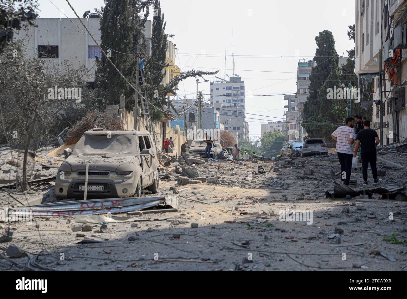 Gaza. 8 ottobre 2023. I palestinesi controllano una strada danneggiata a seguito di un attacco aereo israeliano nella città di Gaza, 8 ottobre 2023. Almeno 493 palestinesi sono stati uccisi e altri 2.751 feriti in attacchi aerei israeliani sulla Striscia di Gaza, ha detto lunedì il ministero della salute gestito da Hamas, mentre il notiziario statale Kan TV di Israele ha riferito che il bilancio delle vittime in Israele ha raggiunto i 700. Crediti: Rizek Abdeljawad/Xinhua/Alamy Live News Foto Stock
