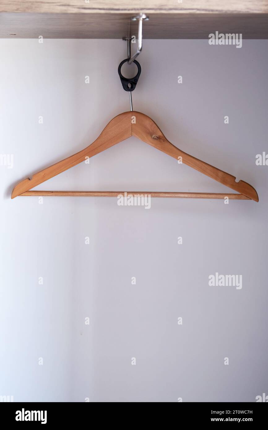 Un appendiabiti in legno vuoto appeso in un armadio. Foto Stock