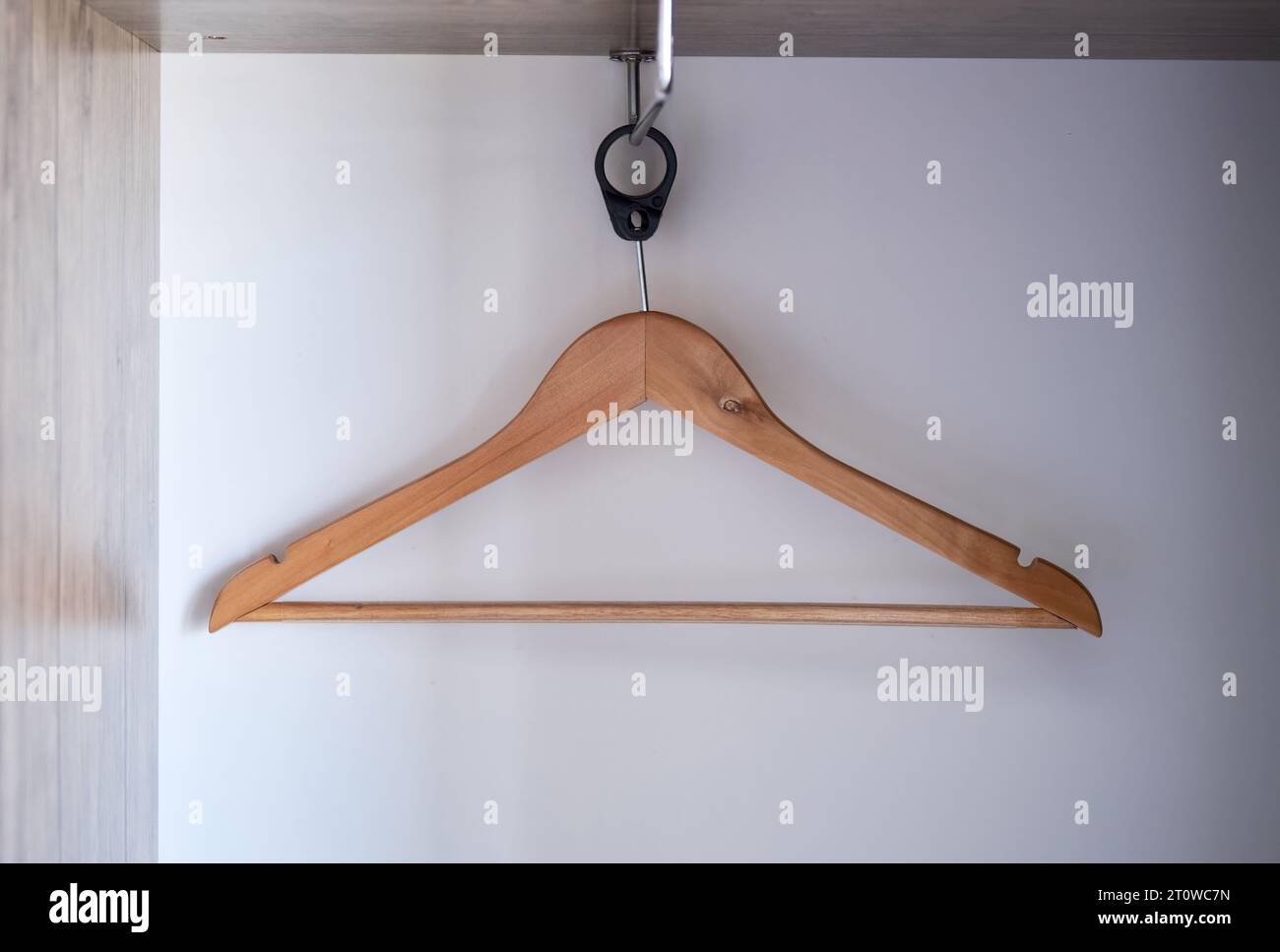Un appendiabiti in legno vuoto appeso in un armadio. Foto Stock