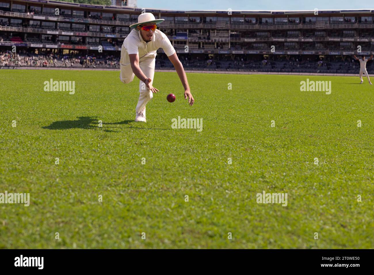 Un fielder sta per prendere la palla durante una partita di cricket Foto Stock