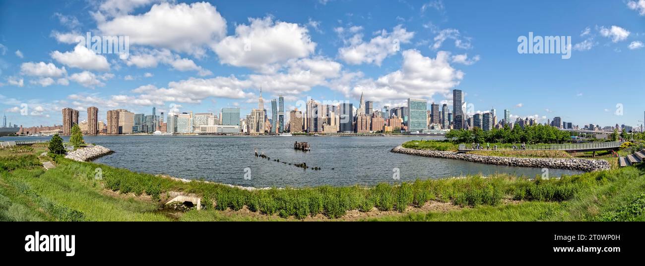 Vista panoramica a ovest da Hunters Point South Park, Queens. Midtown Manhattan è proprio davanti, il familiare skyline orientale sotto nuvole di gonfiori. Foto Stock