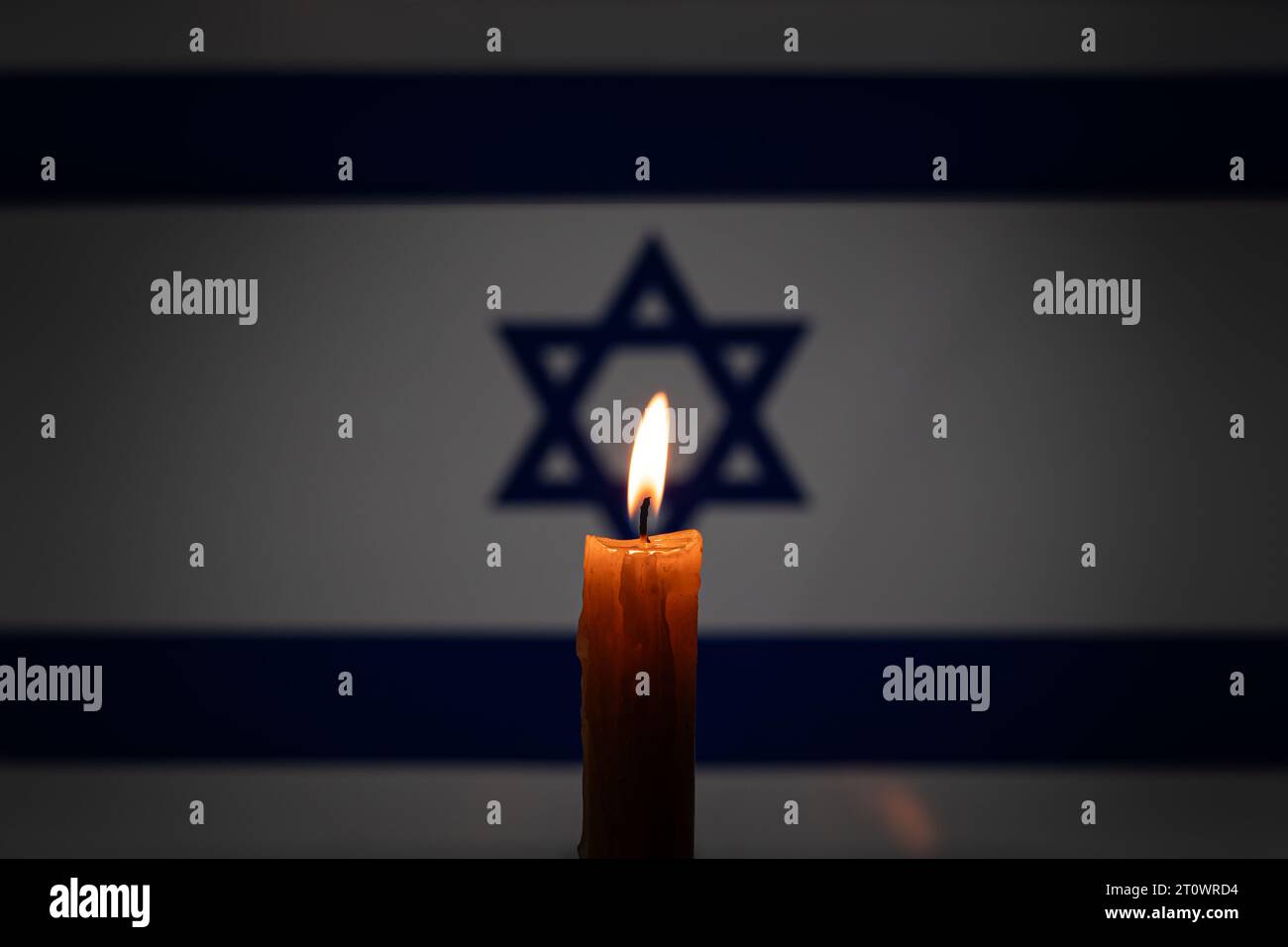 Lutto nel paese Israele. Una candela accesa sullo sfondo della bandiera israeliana. Vittime del cataclisma o del concetto di guerra. Memorial Day dell'Olocausto, Remem Foto Stock