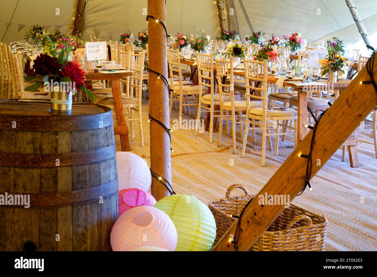 Tendone per matrimoni decorato e pronto per l'arrivo degli ospiti. Tavoli, sedie, fiori e ambientazioni. Una tenda rustica dal design teepee. Foto Stock