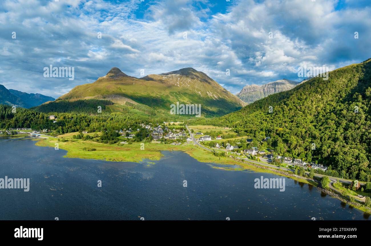 Panorama aereo del lago d'acqua dolce loch Leven con il villaggio di Glen Coe, sopra di esso, il Pap of Glencoe, Highlands, Scozia, alto 742 metri Foto Stock