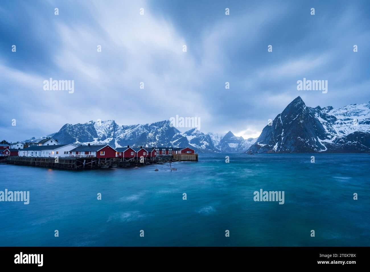 Cabine Rorbuer di Hamnoy vicino al fiordo, montagne innevate sul retro, Hamnoy, Reine, Moskenesoya, Lofoten, Norvegia Foto Stock Cabine Rorbuer di Hamnoy vicino al fiordo, montagne innevate sul retro, Hamnoy, Reine, Moskenesoya, Lofoten, Norvegia Foto Stock