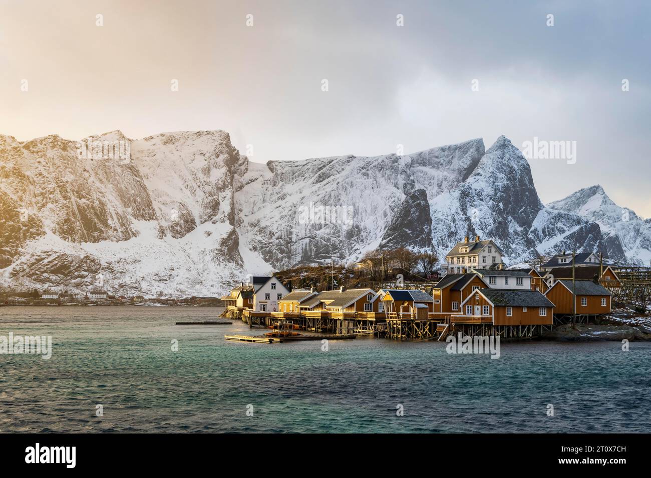 Cabine gialle tradizionali rorbuer sull'isola Sakrisoy, montagne rocciose innevate sul retro, Sakrisoy, Reine, Lofoten, Norvegia Foto Stock Cabine gialle tradizionali rorbuer sull'isola Sakrisoy, montagne rocciose innevate sul retro, Sakrisoy, Reine, Lofoten, Norvegia Foto Stock