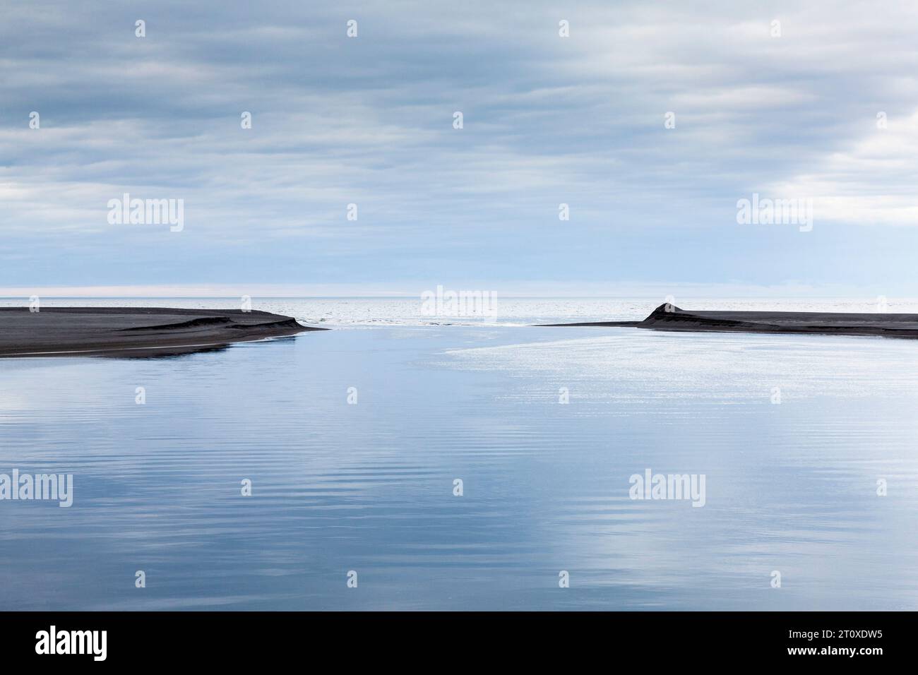 Due barre di sabbia nere che separano la laguna dall'oceano, nel nord-est dell'Islanda Foto Stock