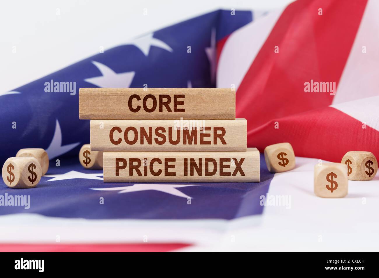 Economia e finanza. Sulla bandiera degli Stati Uniti giacciono cubetti con il simbolo del dollaro e stampi di legno con l'iscrizione - core consumer pr Foto Stock