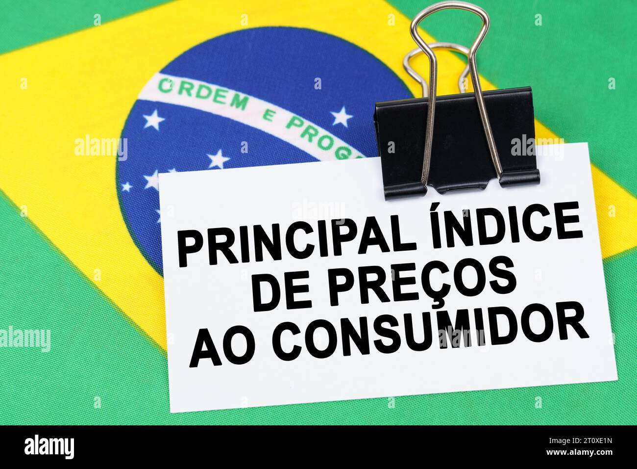 Economia e finanza. Sulla bandiera del Brasile si trova un biglietto da visita con l'iscrizione - indice dei prezzi al consumo di base. Testo in portoghese. Foto Stock