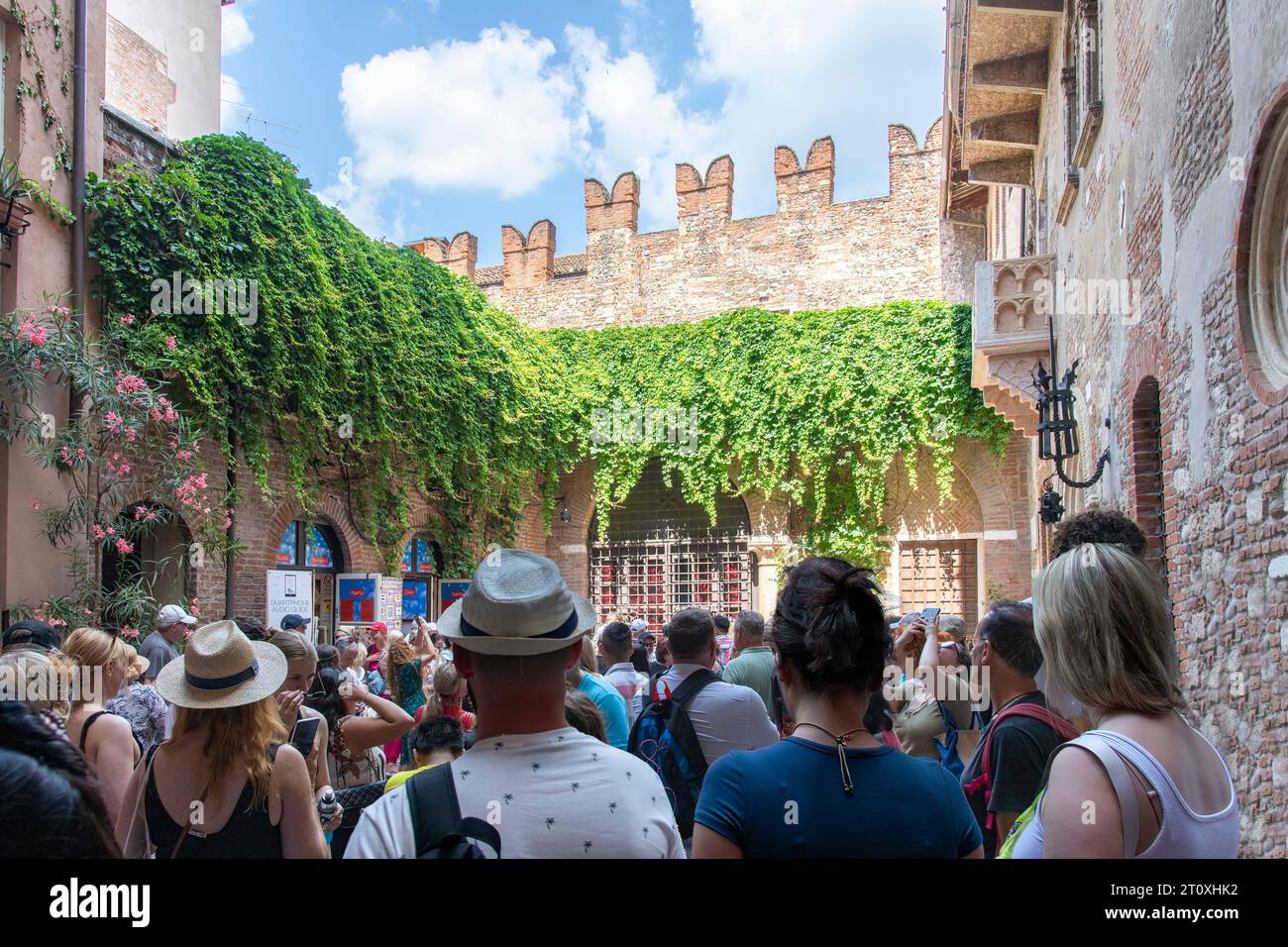 Verona, Italia-12 giugno 2023; cortile pieno di turisti di fronte al balcone in pietra della Casa di Giulietta in stile gotico, che si dice abbia ispirato Guglielmo Foto Stock