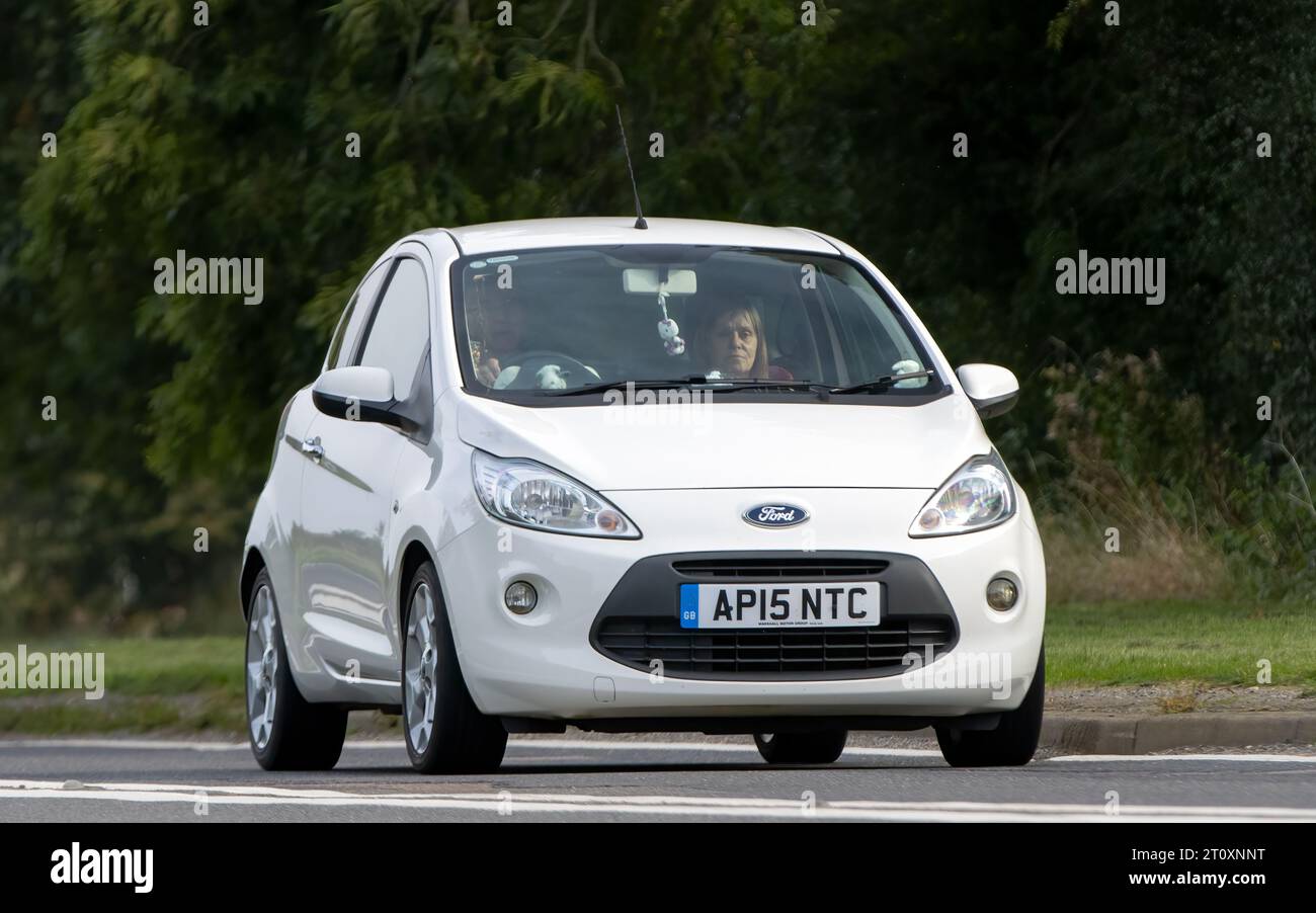 Bicester, Oxon., UK - 8 ottobre 2023: 2015 auto d'epoca Ford Ka bianca che guida su una strada di campagna inglese. Foto Stock