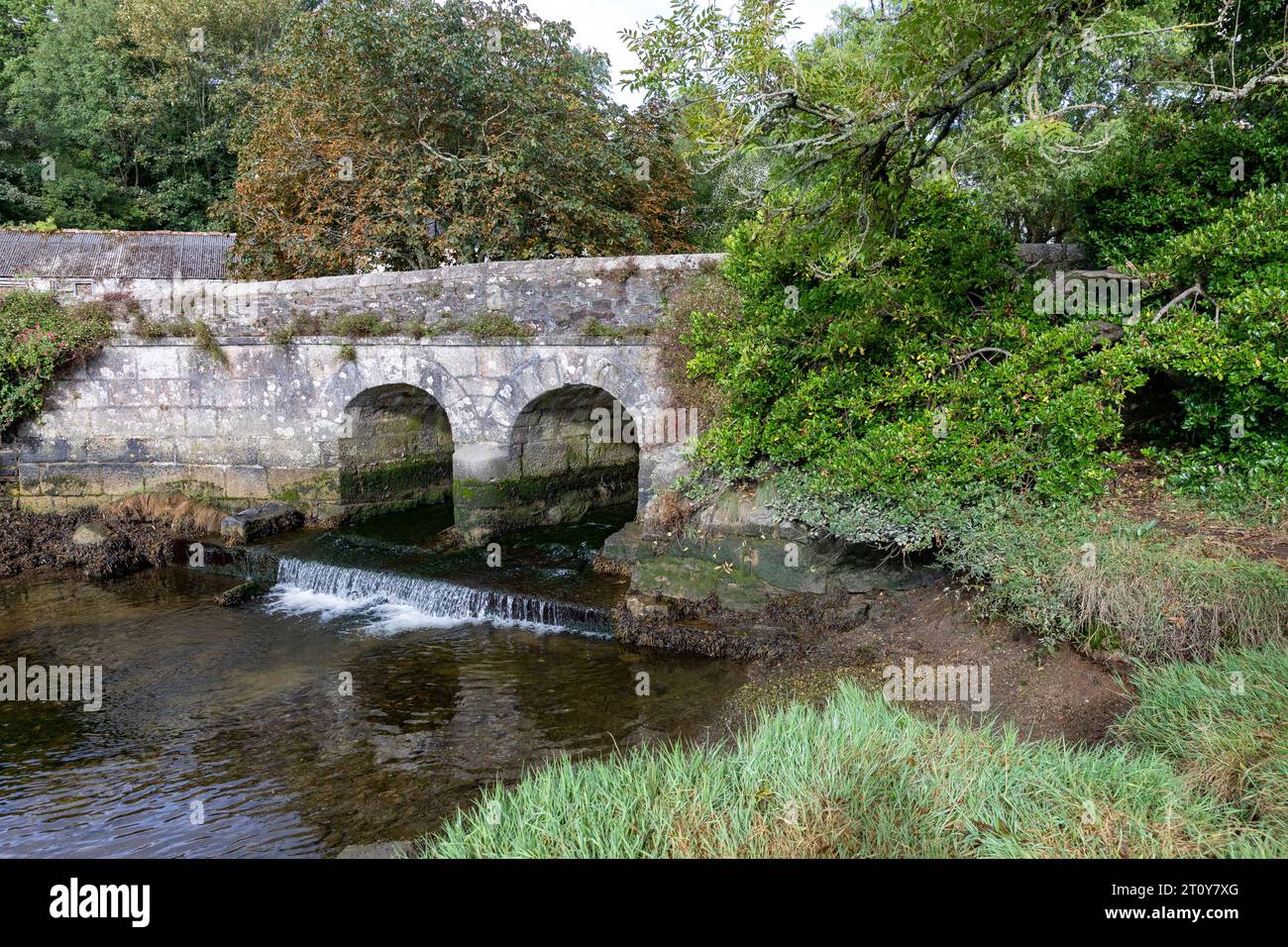 Gweek villaggio in Cornovaglia, l'estuario di Telford scorre sotto il vecchio ponte in pietra a due archi, Inghilterra, Regno Unito, settembre 2023 Foto Stock