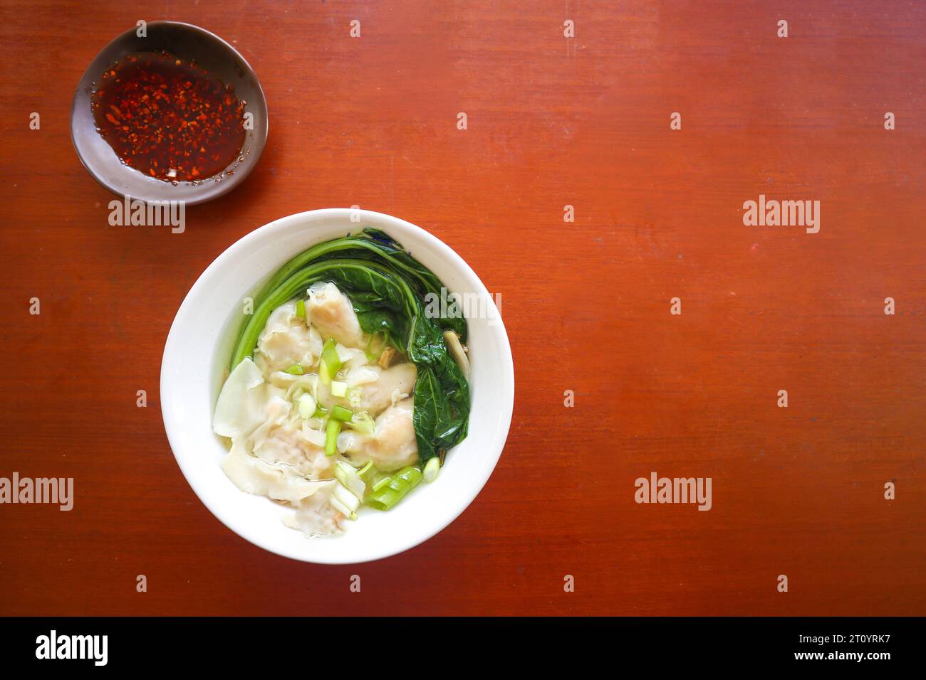 zuppa wonton. Ciotola di zuppa wonton con olio di peperoncino. Zuppa di gamberi o gnocchi di carne con senape , cipolle verdi, Foto Stock