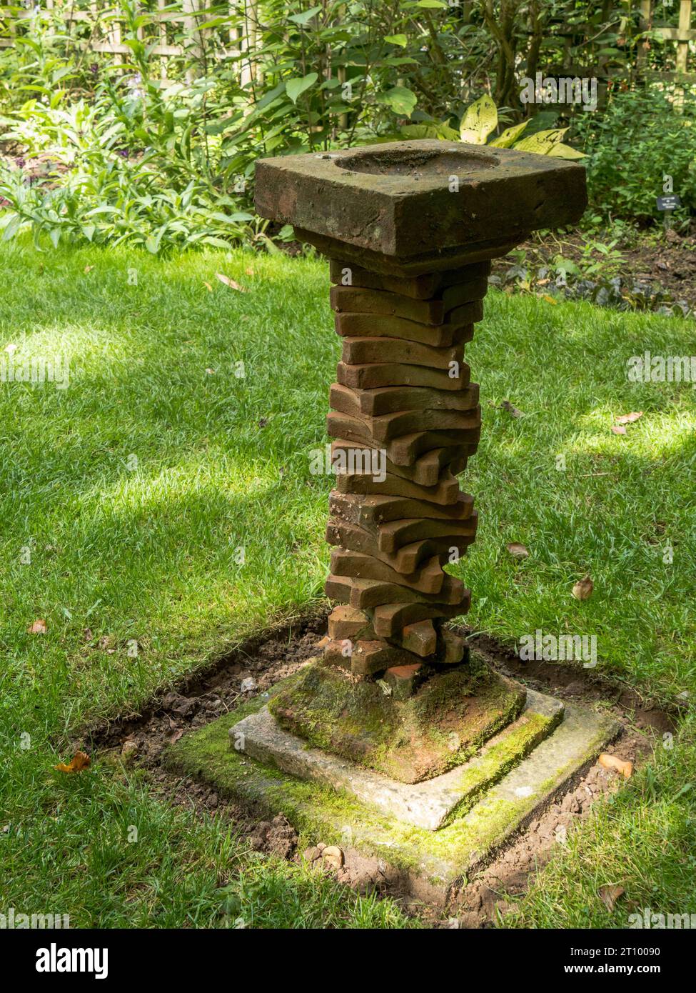 Bagno di uccelli fatto in casa con una colonna composta da una spirale di piastrelle di argilla vittoriana, Barnsdale Gardens, Oakham, Rutland, Inghilterra, REGNO UNITO. Foto Stock