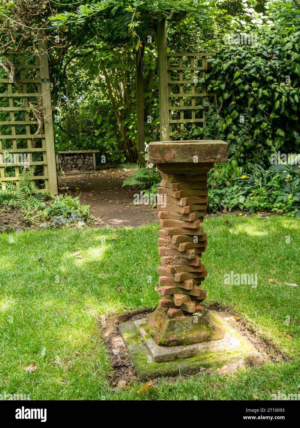 Bagno di uccelli fatto in casa con una colonna composta da una spirale di piastrelle di argilla vittoriana, Barnsdale Gardens, Oakham, Rutland, Inghilterra, REGNO UNITO. Foto Stock