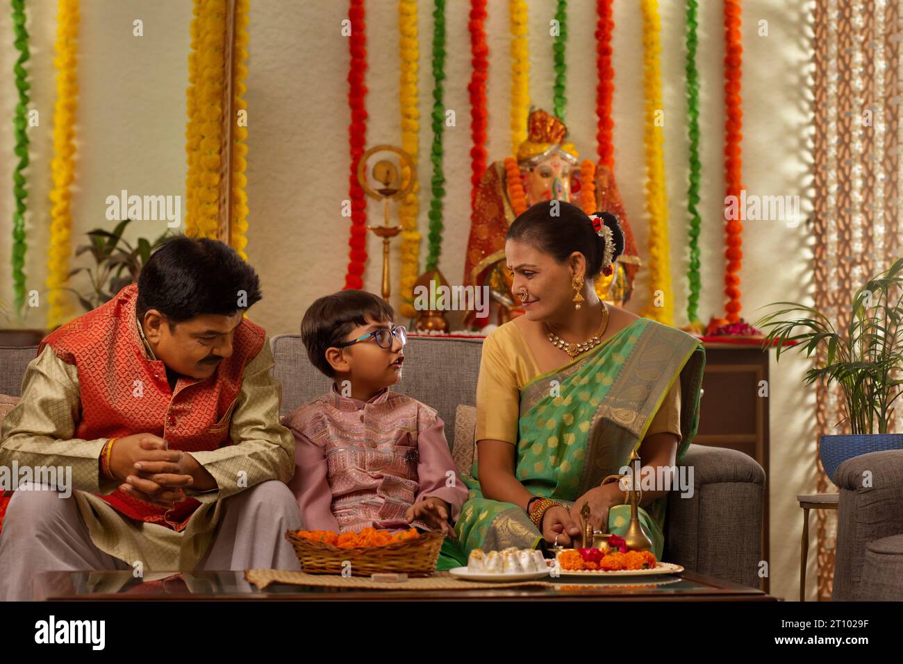 I nonni hanno una conversazione con il loro nipote durante Ganesh Chaturthi un festival celebrato nel Maharashtra ( India occidentale ) Foto Stock