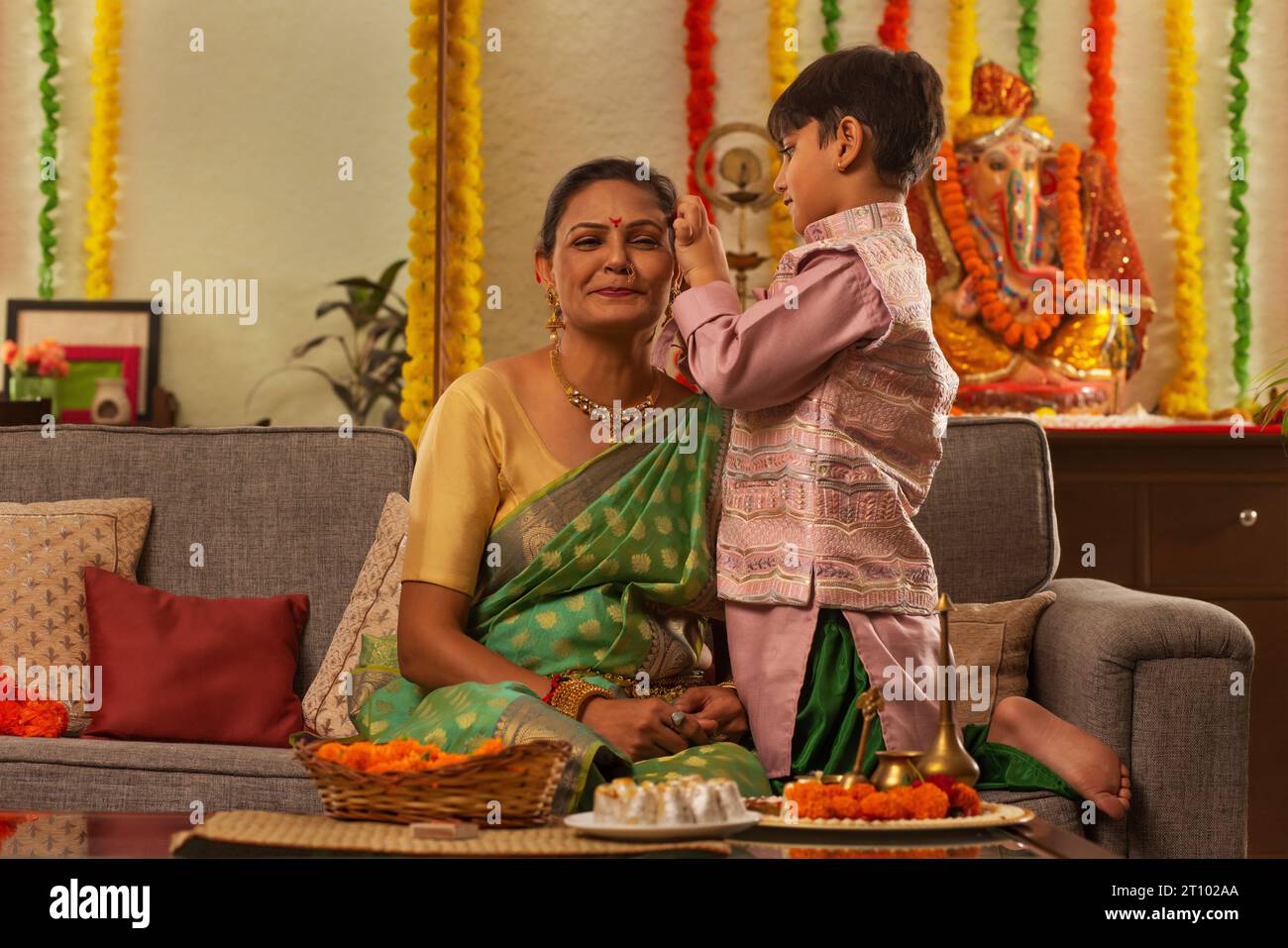 Nipote regola i capelli della nonna durante Ganesh Chaturthi una festa celebrata nel Maharashtra ( India occidentale ) Foto Stock