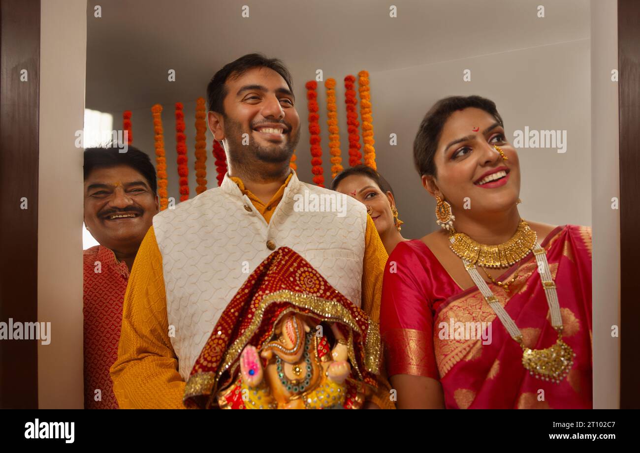 Famiglia che porta a casa Lord Ganesh durante Ganesh Chaturthi una festa celebrata nel Maharashtra ( India occidentale ) Foto Stock