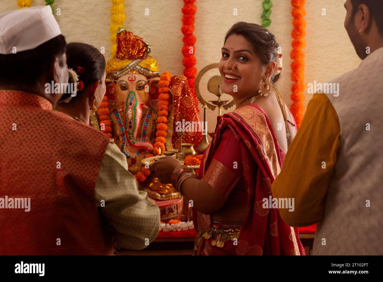 Famiglia Maharashtrian che prega il Signore Ganesha in occasione di Ganesh Chaturthi Foto Stock