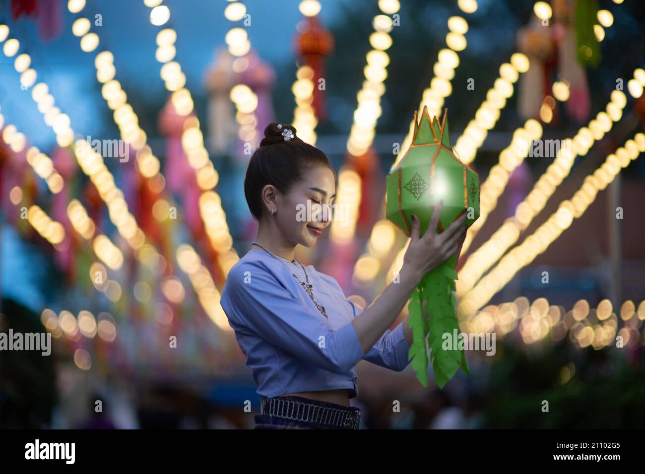 Bellissime donne asiatiche che tengono una tradizionale lanterna di carta durante il festival delle lanterne di Yi peng al Wat Phra That Hariphunchai, provincia di Lamphun, Thailandia. Foto Stock