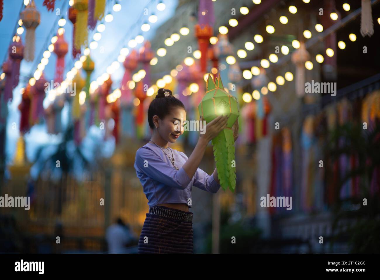 Bellissime donne asiatiche che tengono una tradizionale lanterna di carta durante il festival delle lanterne di Yi peng al Wat Phra That Hariphunchai, provincia di Lamphun, Thailandia. Foto Stock