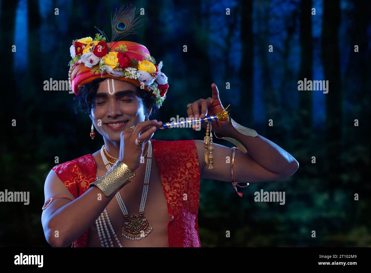 Ritratto di un giovane vestito da Lord Krishna e che suona il flauto in occasione di Janmashtami Foto Stock