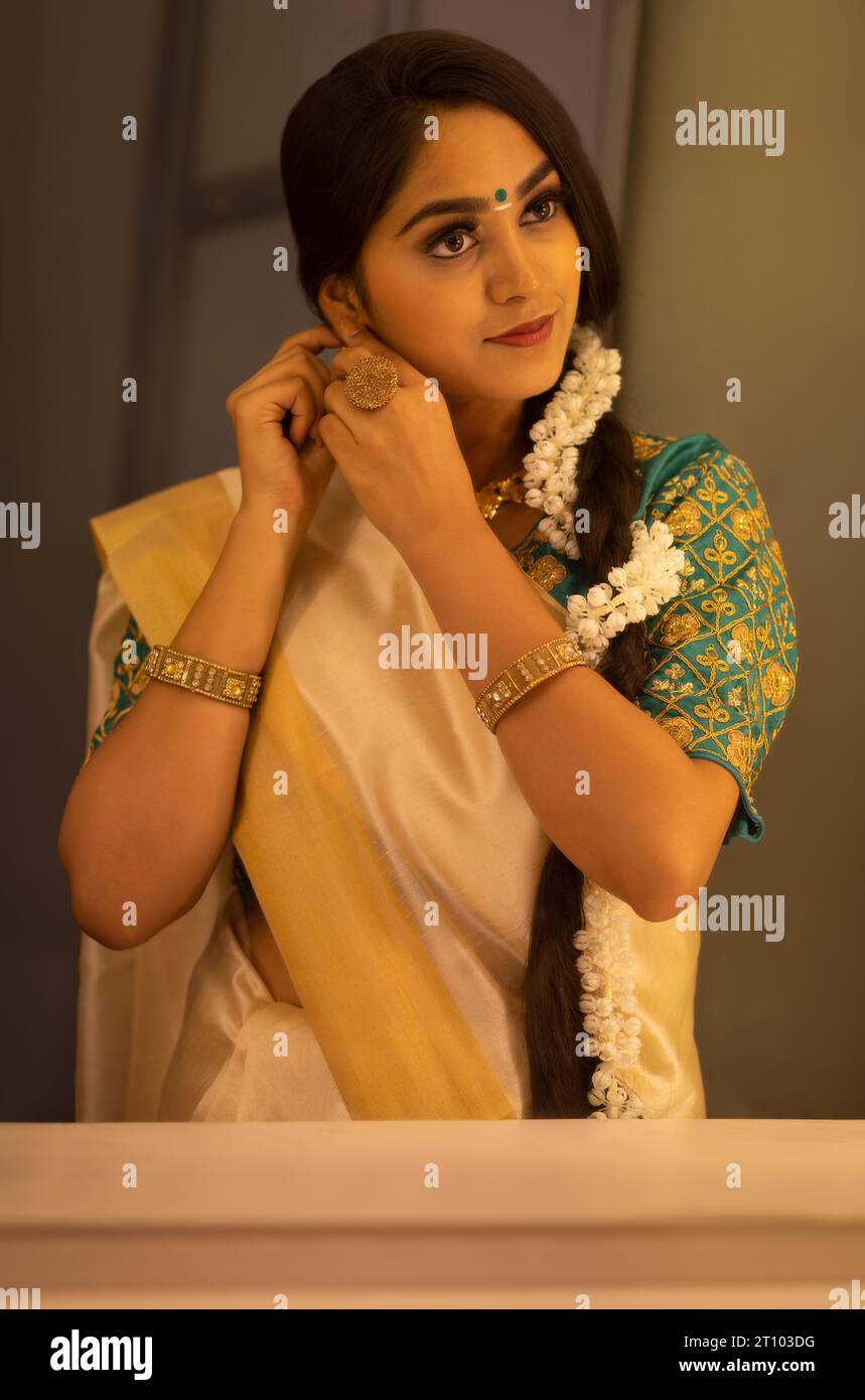 Donna che si veste davanti allo specchio in occasione di Onam Foto Stock