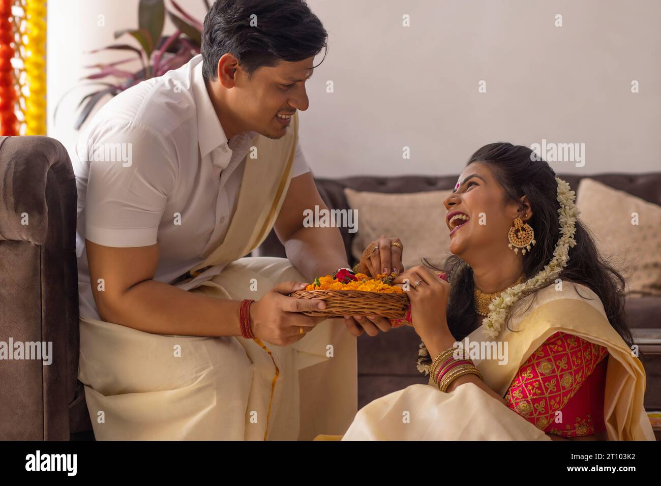 Felice coppia dell'India del Sud che festeggia Onam a casa Foto Stock